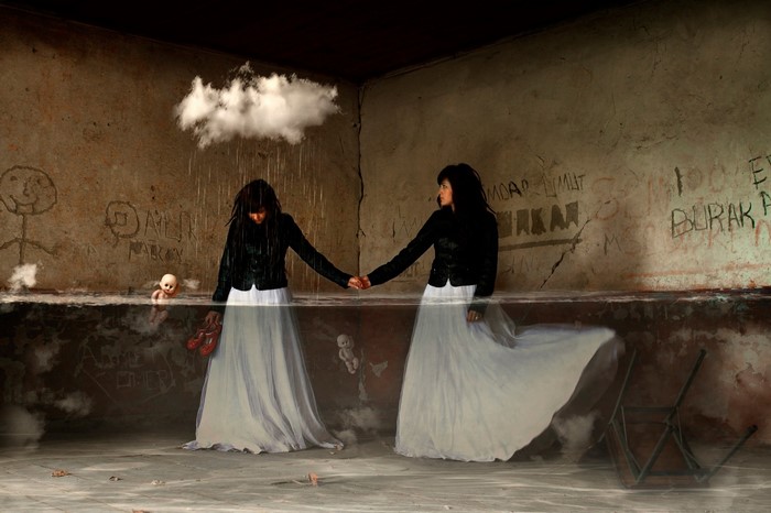 Two women in dresses holding hands in a flooded room