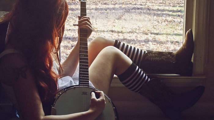 Woman Sitting by Window Playing Banjo