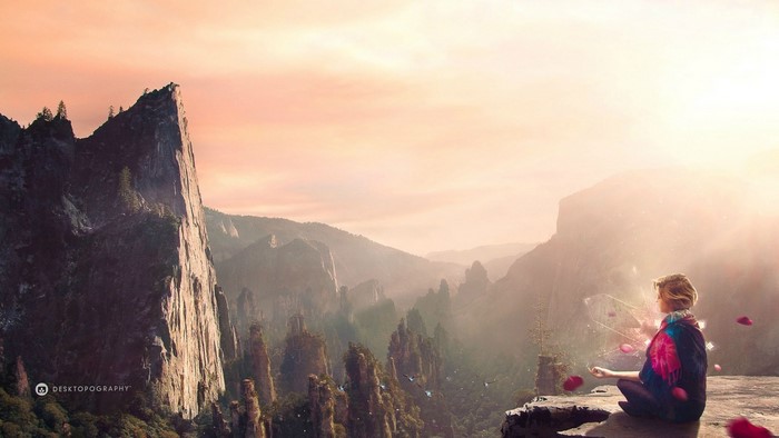 Woman meditating on a cliff at sunset with mountains