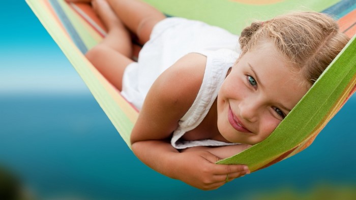 Girl relaxing in a hammock by the ocean