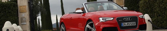 Red Audi RS5 Convertible parked near a gate