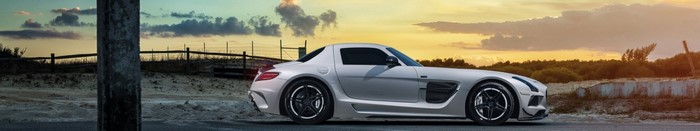 White Mercedes SLS sports car on road at sunset