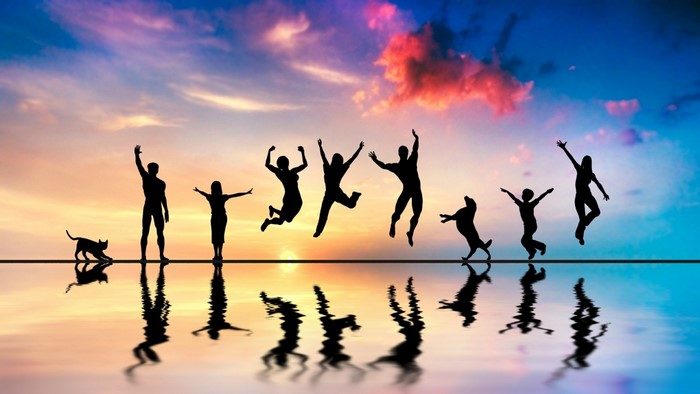 Silhouettes of people and animals jumping at sunset with reflections