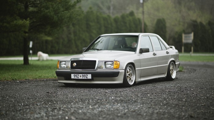 Silver Mercedes-Benz 190E W201 sedan on gravel