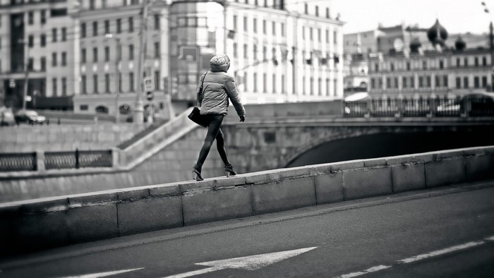 Woman walking on a city embankment in black and white