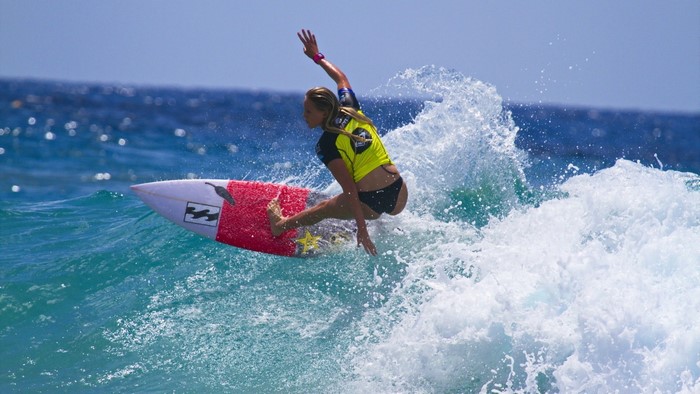 Woman surfing a wave on a Billabong surfboard