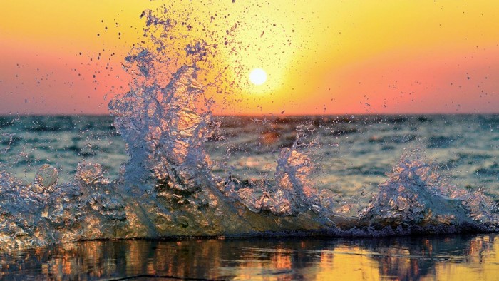 Wave splashing at sunset over the ocean