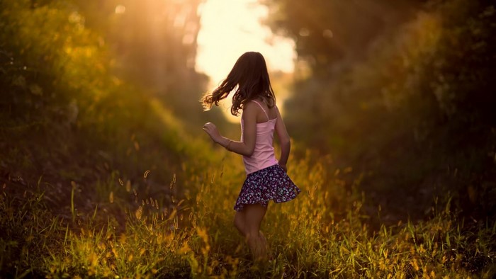 Girl dancing in a sunlit meadow