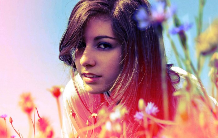 Young woman with flowers in a field