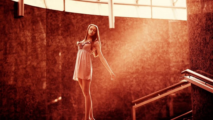 Woman in a light pink dress standing on stairs