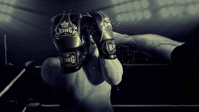 Boxer wearing Top King gloves in a boxing ring