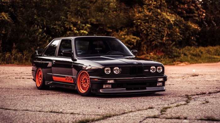 Black BMW M3 E30 with orange wheels