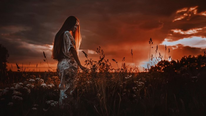 Woman in a field at sunset