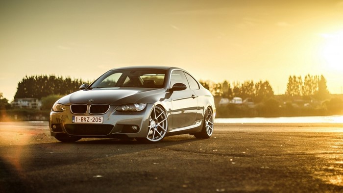 BMW 3 Series Coupe on a road at sunset