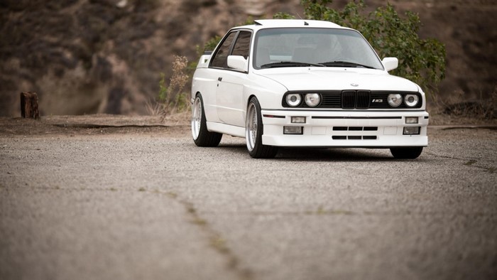 White BMW M3 E30 parked on a gravel road