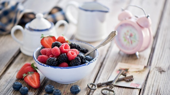 Bowl of berries with a pink alarm clock