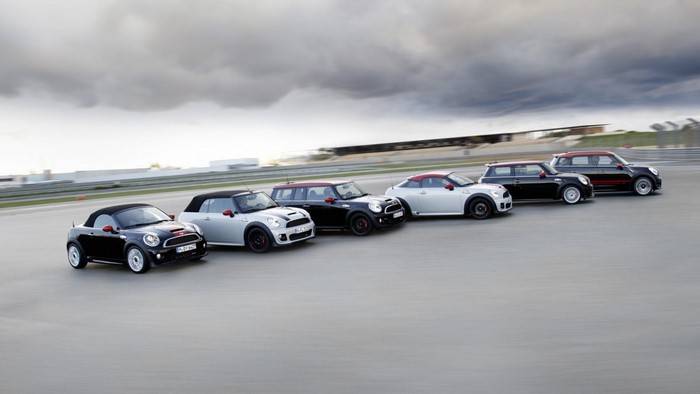 Multiple Mini Cooper models lined up on a race track