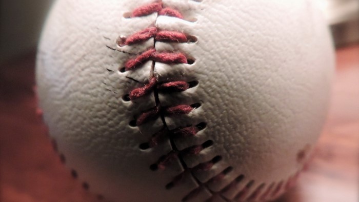 Close up of a baseball with red stitching