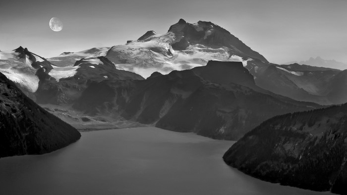 Monochrome mountain landscape with moon and lake