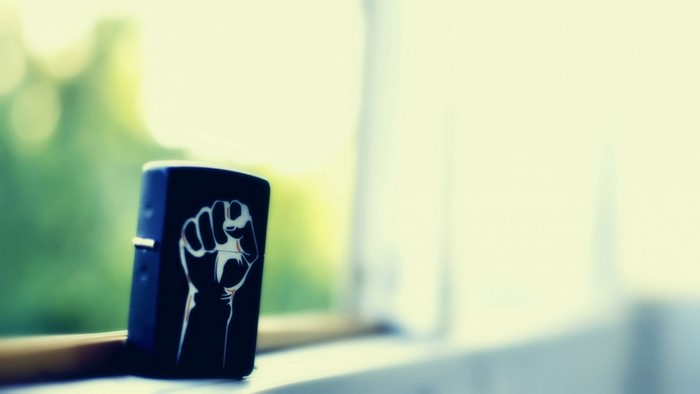 Black lighter with raised fist symbol on windowsill