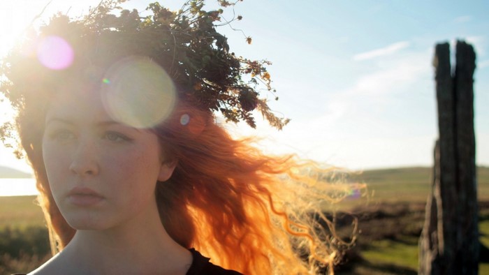 Woman with flower wreath in sunlight