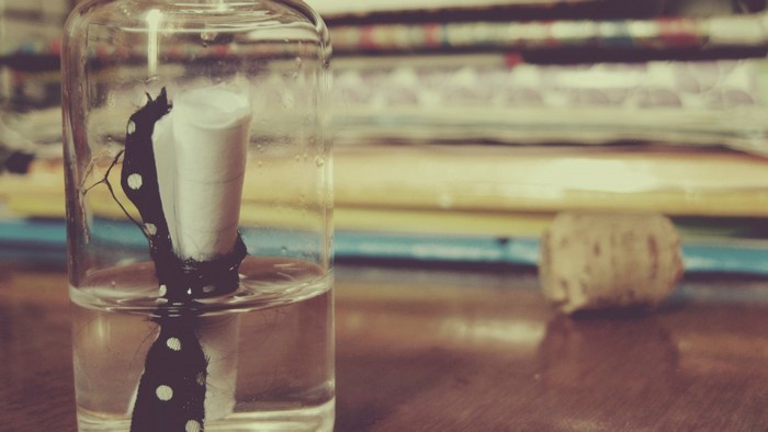 Message in a bottle with cork and books