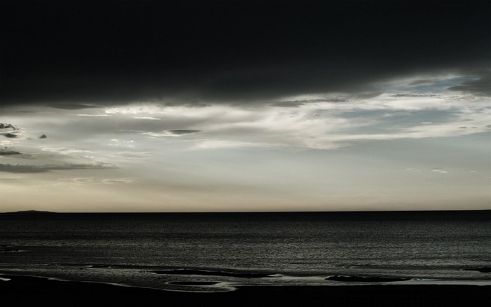 Dark clouds over the ocean at dusk
