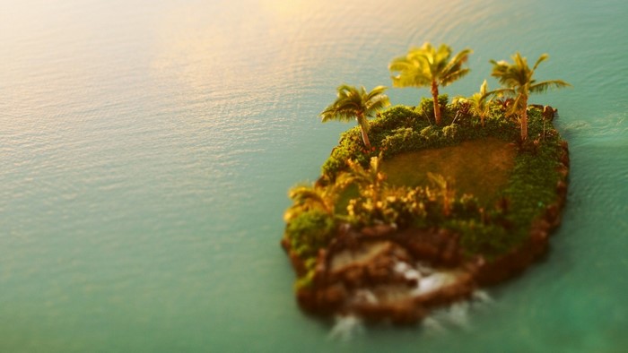 Tiny tropical island with palm trees in the ocean