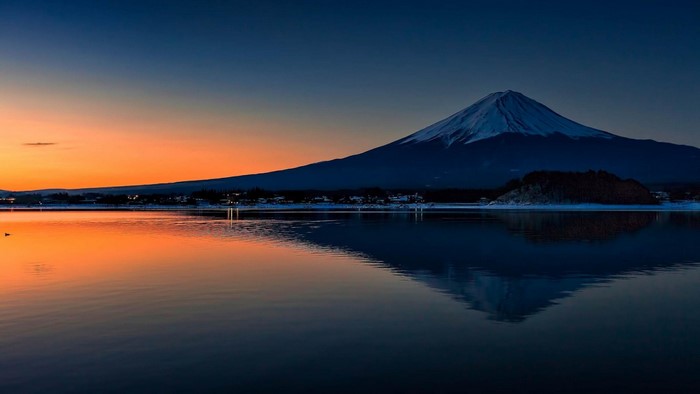 Mount Fuji reflected in a lake at sunset