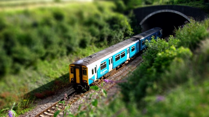 Blue and yellow train approaching a tunnel
