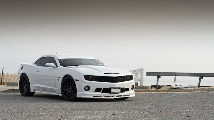 White Chevrolet Camaro parked by the ocean