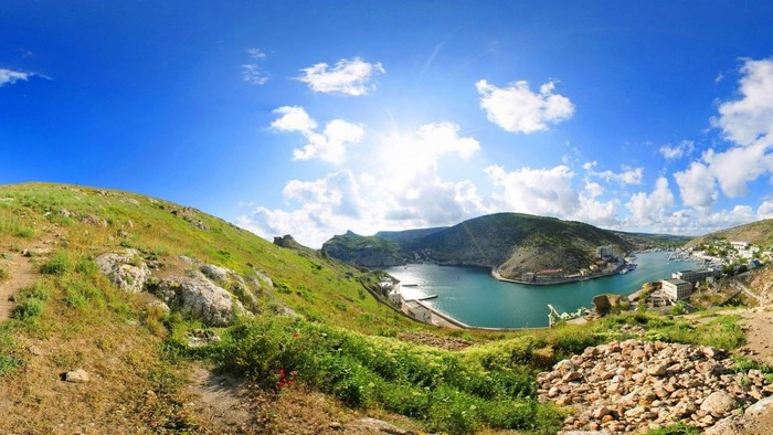 Panoramic view of a bay with mountains and a town