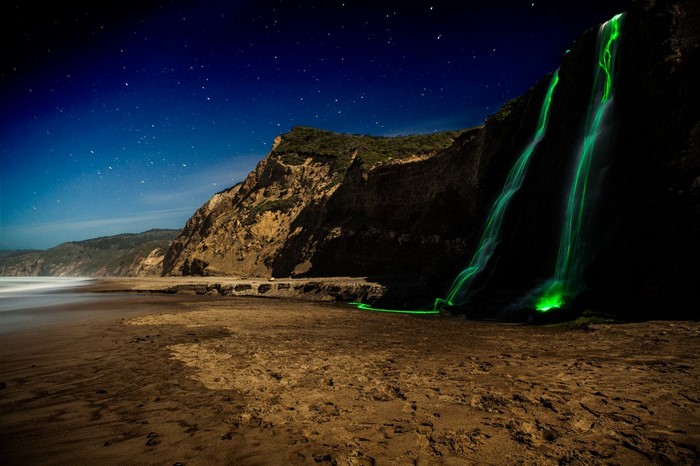 Glowing Waterfall on a Beach at Night