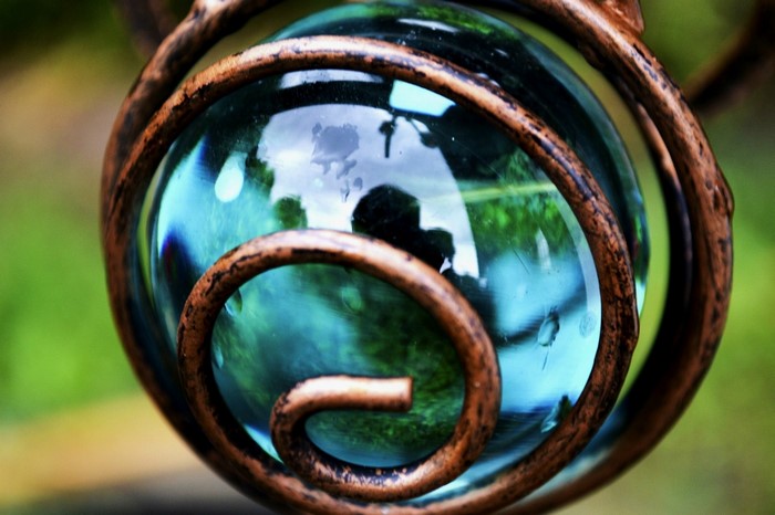 Close-up of a glass orb in a spiral metal frame