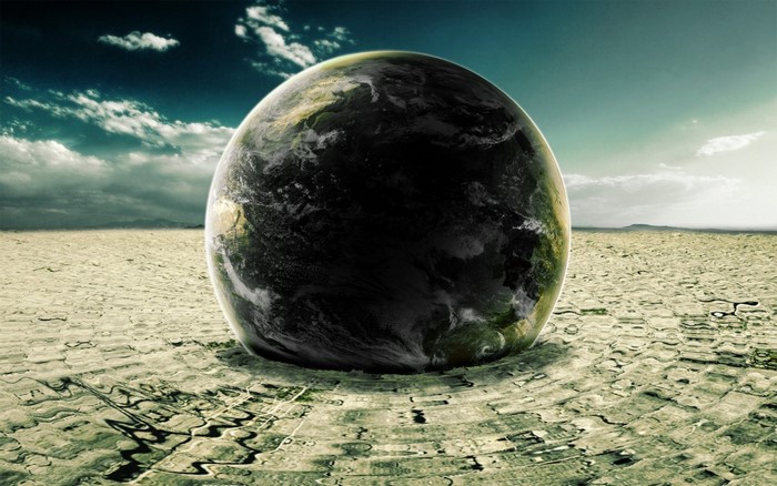 Earth planet on cracked dry ground with clouds