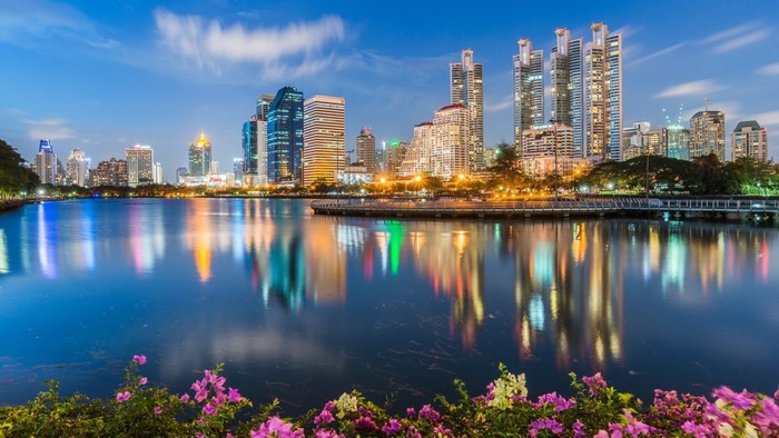 Bangkok cityscape with lake and flowers at dusk