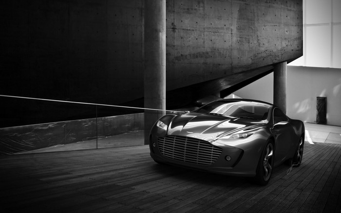 Monochrome Aston Martin sports car in modern architecture