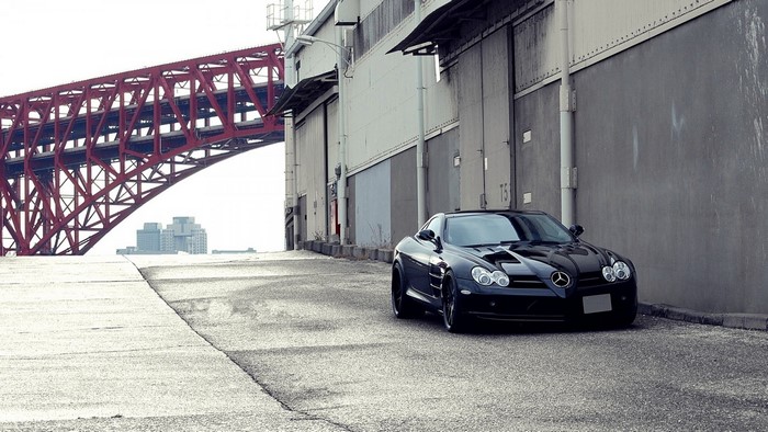 Black Mercedes Benz SLR McLaren parked near a bridge