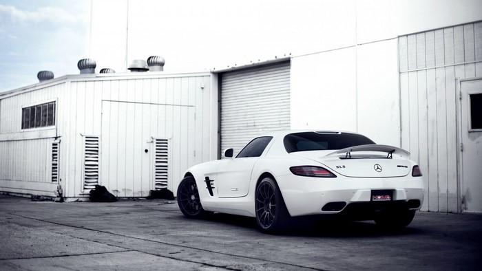 White Mercedes-Benz SLS AMG parked near a building