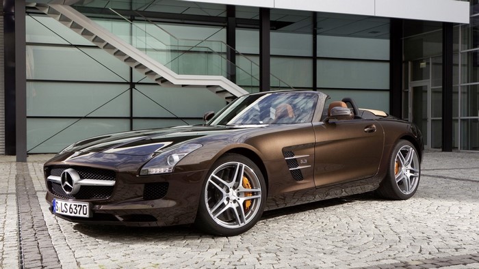 Brown Mercedes-Benz SLS AMG Roadster parked outside modern building
