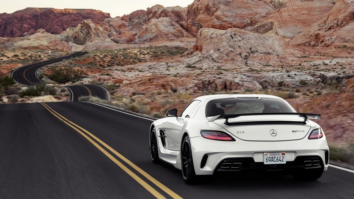 White Mercedes-Benz SLS AMG driving on a desert road
