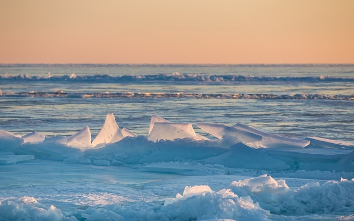 Ice formations on a body of water at sunset