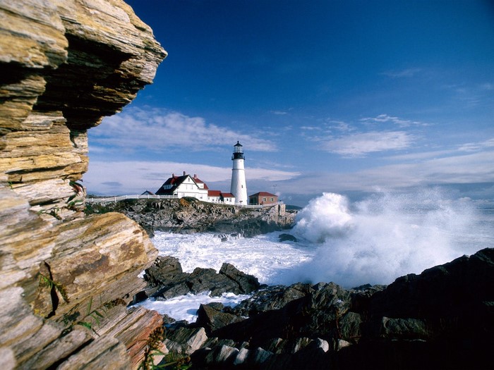 Portland Head Light lighthouse on a rocky coast with crashing waves