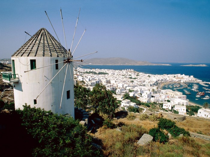 White windmill overlooking a coastal town and the sea