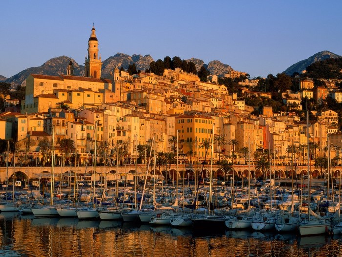 Menton, France: Coastal town with harbor and mountains at dusk