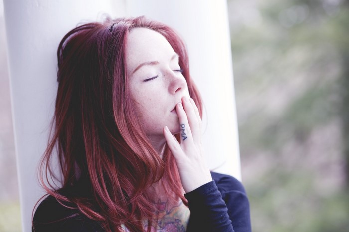 Woman with red hair and freckles, hand on mouth