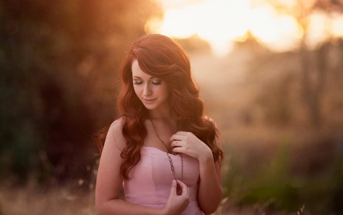 Redhead woman in pink dress with necklace