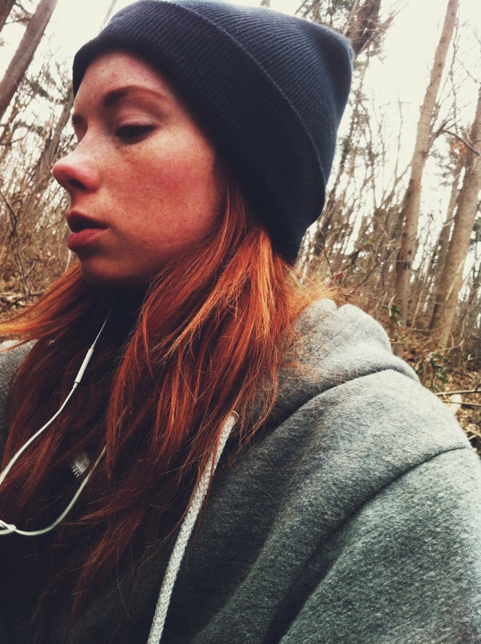 Woman with red hair wearing a beanie and hoodie