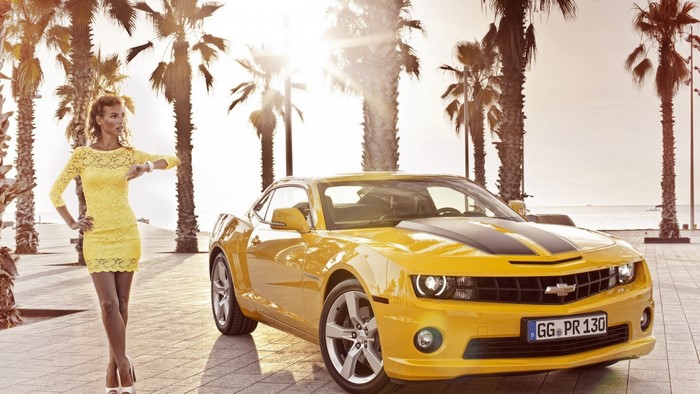 Woman in yellow dress with yellow Chevrolet Camaro