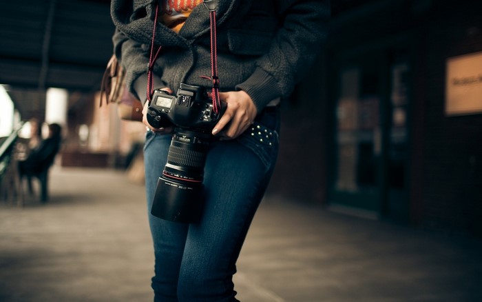 Woman holding a Canon DSLR camera